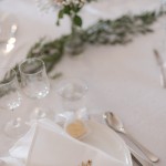 Kartanon juhlasalin valkoiset pöytäliinat sisältyvät tilavuokraan. Saatavilla myös kangasservetit. Juhlakattauksia salissa.